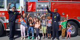 Kids with firefighters and an engine