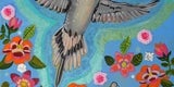 Gray dove with wings spread open ascending over flowers
