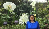 Nirmala Bandrapalli with large flowers behind her