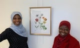 Latifat Apatira and her mother smiling next to her flower painting