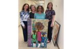 Artist Rebecca Archer stands with her friends as she shows off her Best In Show painting, Unbreakable, which features 3 Black girls.