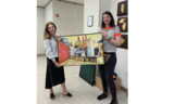 Artist Donna Colson shows off her painting of a magical realist town