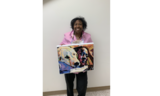 Artist stands with her painting featuring a black woman and her golden retriever