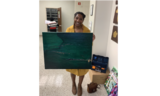 Artist Jasmine Reid stands with her dark green painting