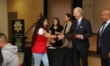 Well-being Academy graduate accepting certificate and shaking hands with leadership