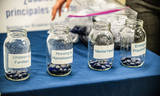 Photo of 4 jars with varying amounts of marbles indicating preference for funding categories.