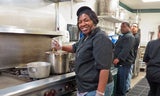A female stirring a pot on the stove