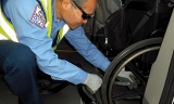 Veteran Redi-Wheels Driver Frank Ng secures Sammi Riley's wheelchair in his custom van. 