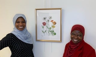 Latifat Apatira and her mother smiling next to her flower painting