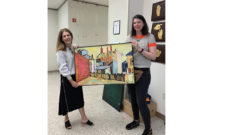 Artist Donna Colson shows off her painting of a magical realist town