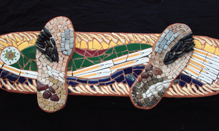 A skateboard and two shoes made out of mosaic tiles, featuring green and yellow