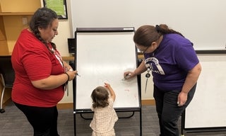 little kid with two teachers