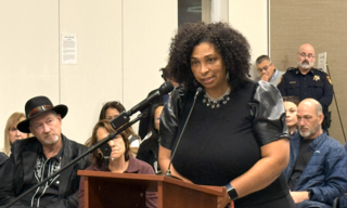 woman speaking into mic at podium