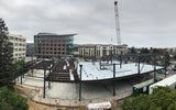 The building begins to take shape as workers install the steel framework.