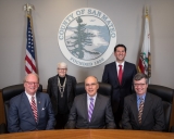 Board of Supervisors standing in front of county seal