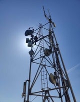 View from the ground of a radio tower with microwave antennas