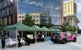 resource tables under tents, pink patrol car