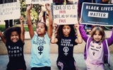 Four children hold signs and wear shirts saying &quot;Black Lives Matter&quot;