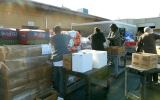 Workers and volunteers unload pallets of food in the parking lot at the Ecumenical Hunger Program in East Palo Alto.