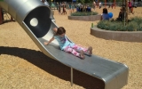 A girl zooms down the new slide at Beresford Park in San Mateo on its grand re-opening.