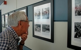 Steve Okamoto examines a 1942 photo of Japanese Americans lined up on San Francisco's Bush Street. Thousands of Japanese Americans were forced into camps following the entry of the United States in World War II.