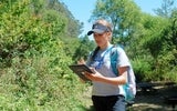 Maria Contreras, the crew leader for the day, posts information about invasive plants on an iPad. A crew will later remove English ivy, purple thistle and other nonnative species.