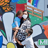 Mother with her children in front of North Fair Oaks mural