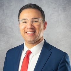 Portrait of man with glass, blue suite, and red tie